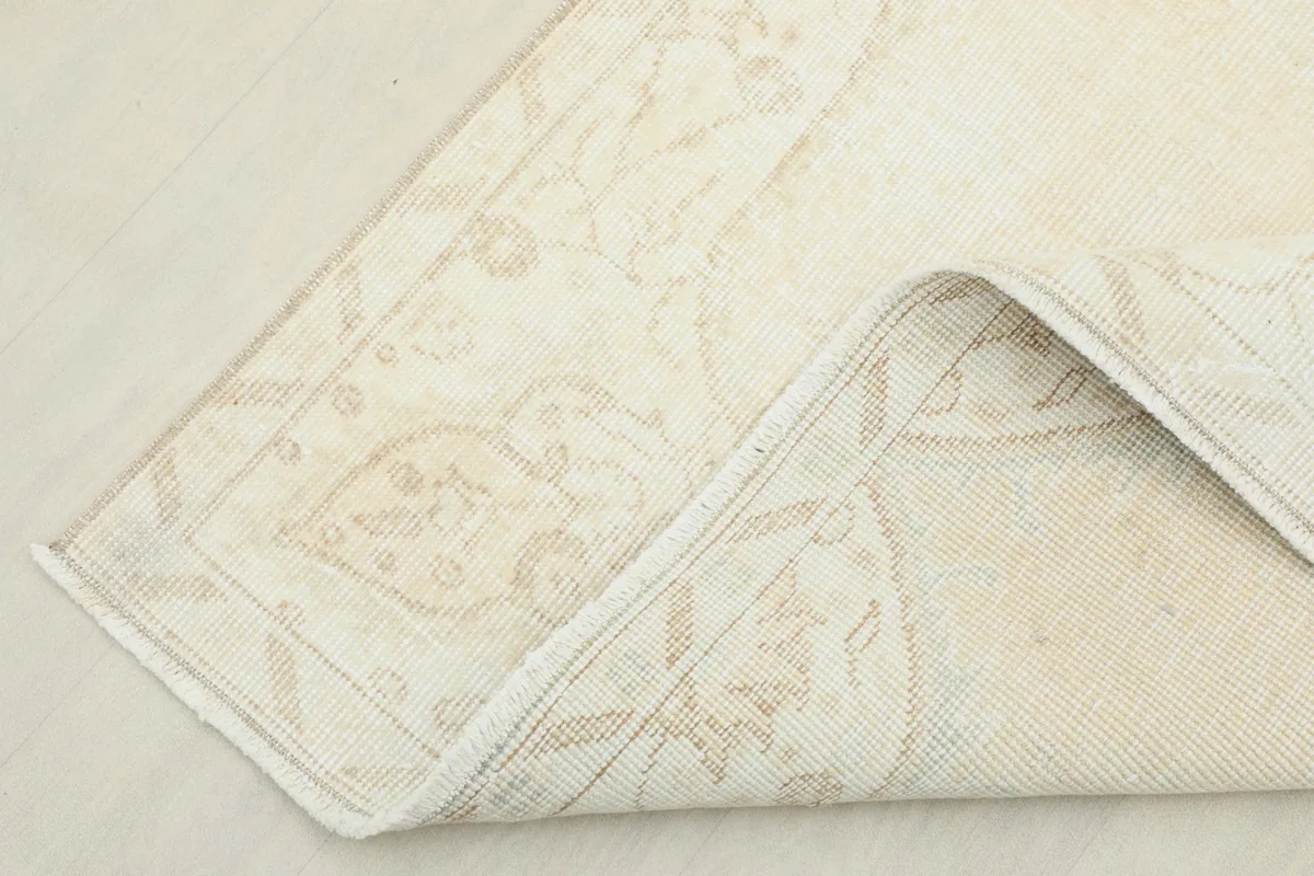 Corner of the rug folded to show the cotton foundation and reverse side of the knots