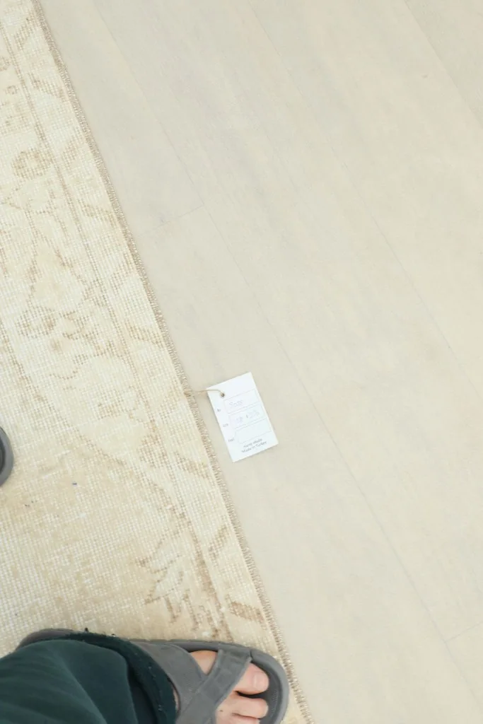 Foot next to the rug, showing scale and the rug's fine texture on the floor
