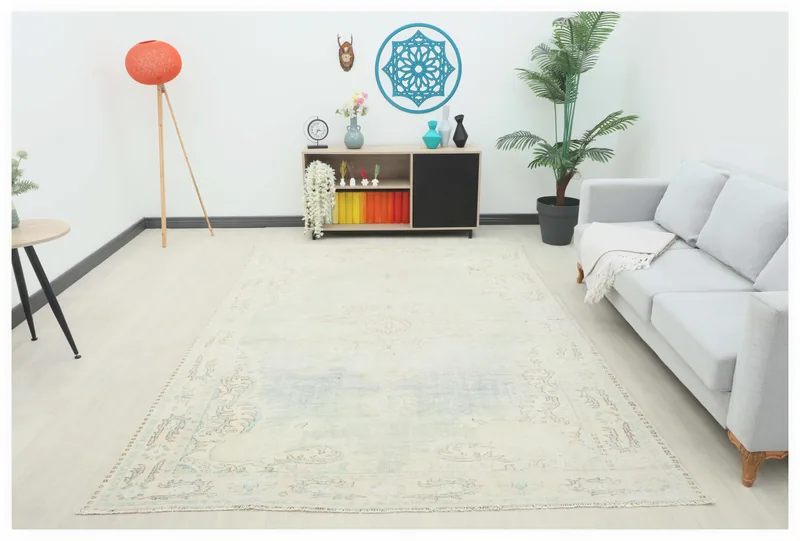 Full top view of the 6'11" x 9'9" beige vintage Anatolian area rug with faded blue and brown motifs