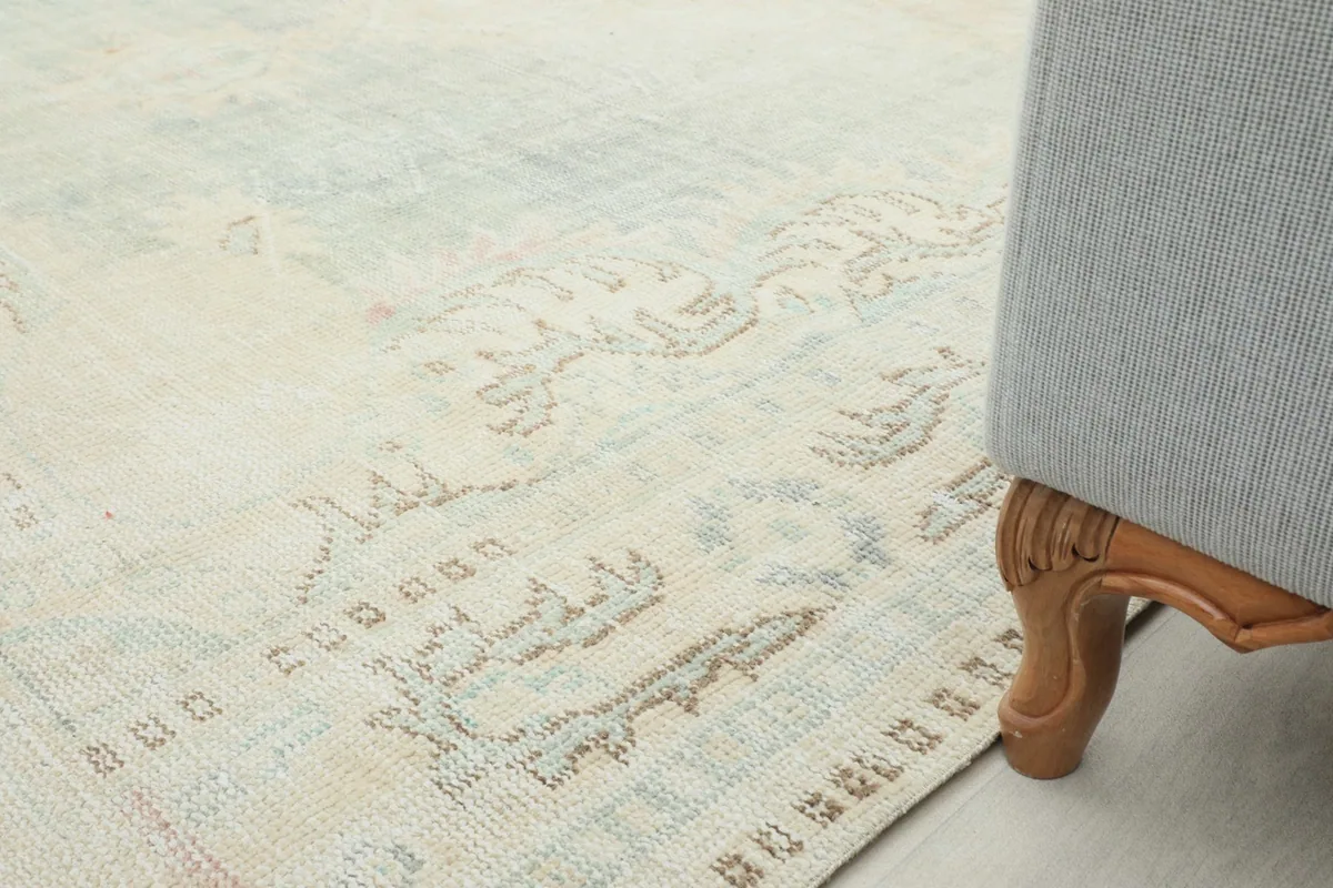 Close-up of the rug's pattern near furniture, demonstrating its distressed look and blending colors