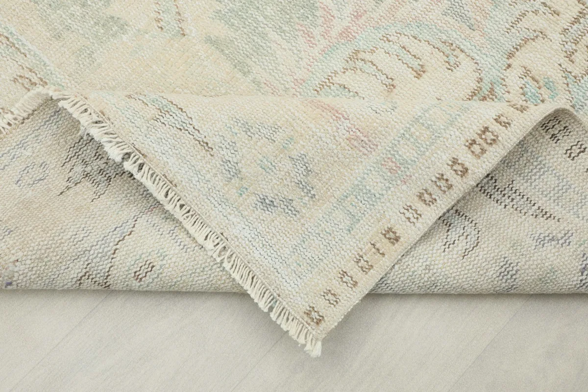 Folded corner of the rug, revealing the reverse side and the hand-knotted construction details