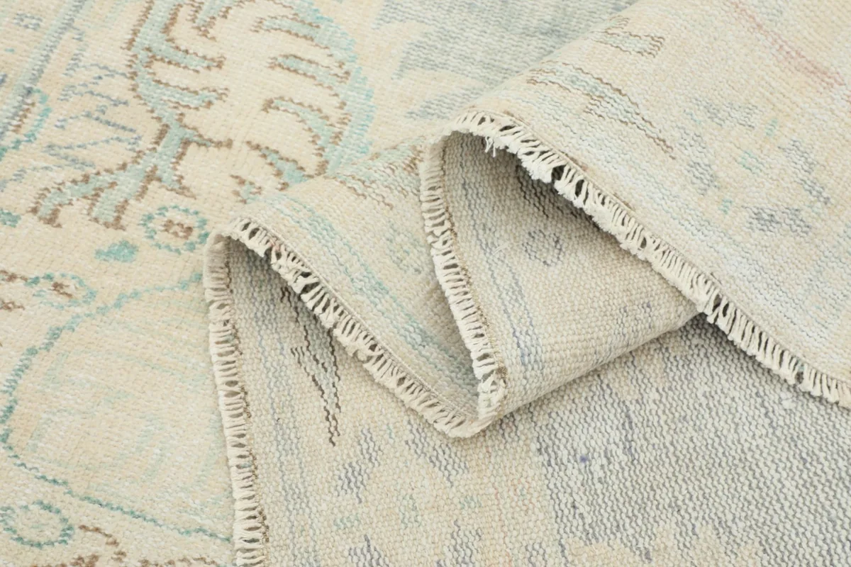 View of the rug folded, showing the thickness of the wool pile and the intricate weaving on the back
