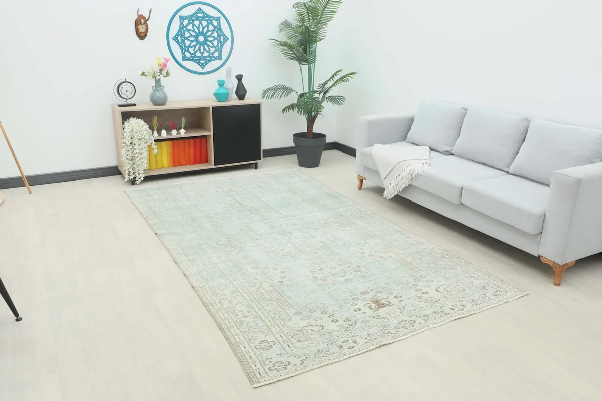 Vintage Anatolian rug with green and beige tones in a modern living room setting