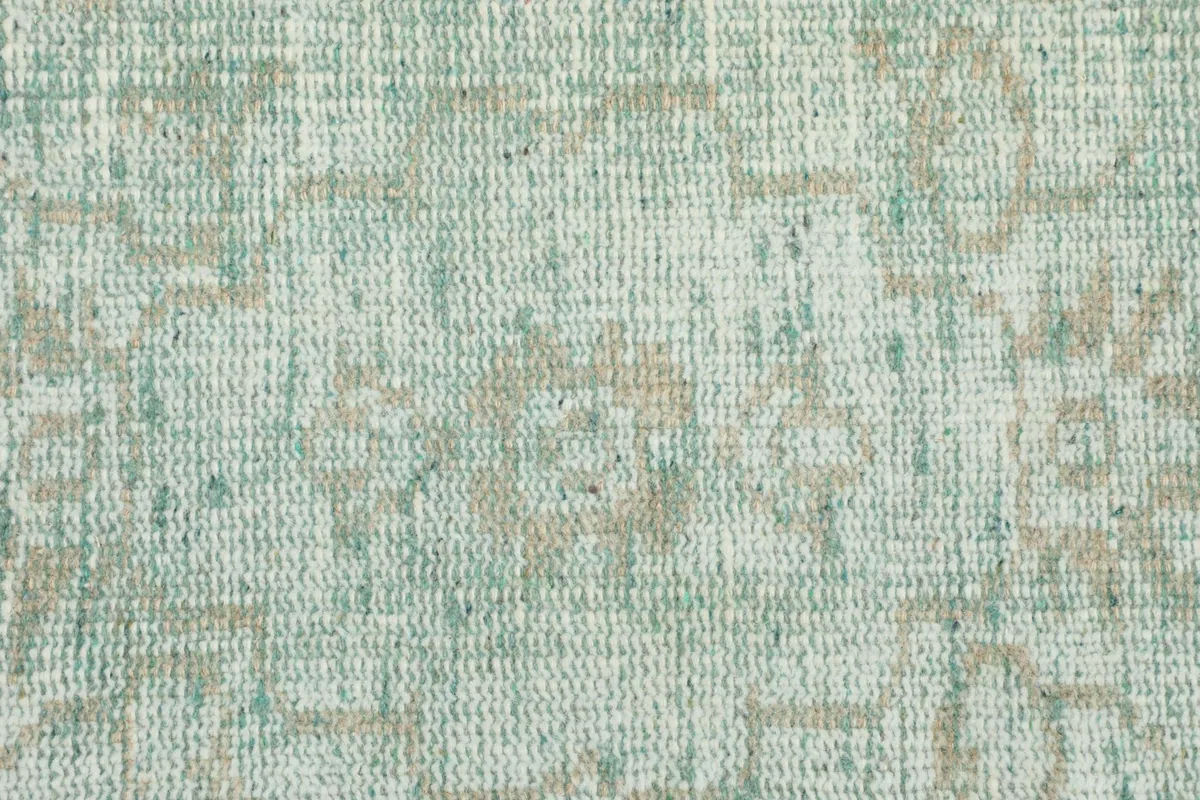 Detailed close-up of the low wool pile texture and distressed geometric patterns