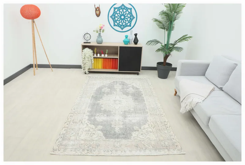 Full overhead view of the gray and beige vintage Anatolian rug on a white floor