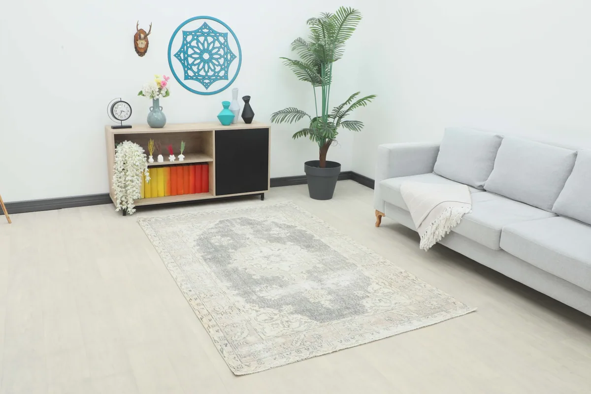 Vintage Anatolian rug in a living room setting with a light gray sofa and wooden console