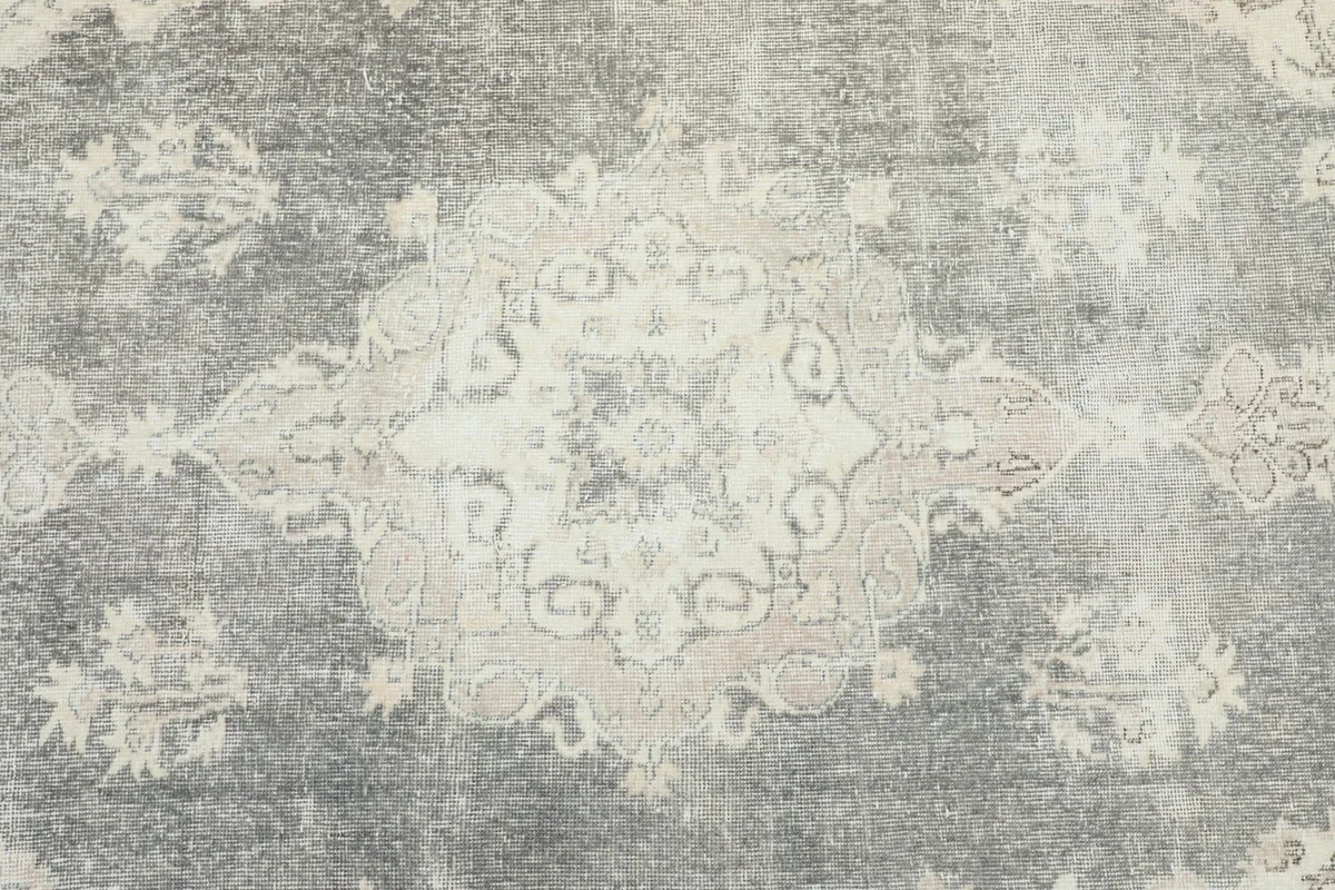 Detailed view of the central gray medallion motif with subtle beige accents