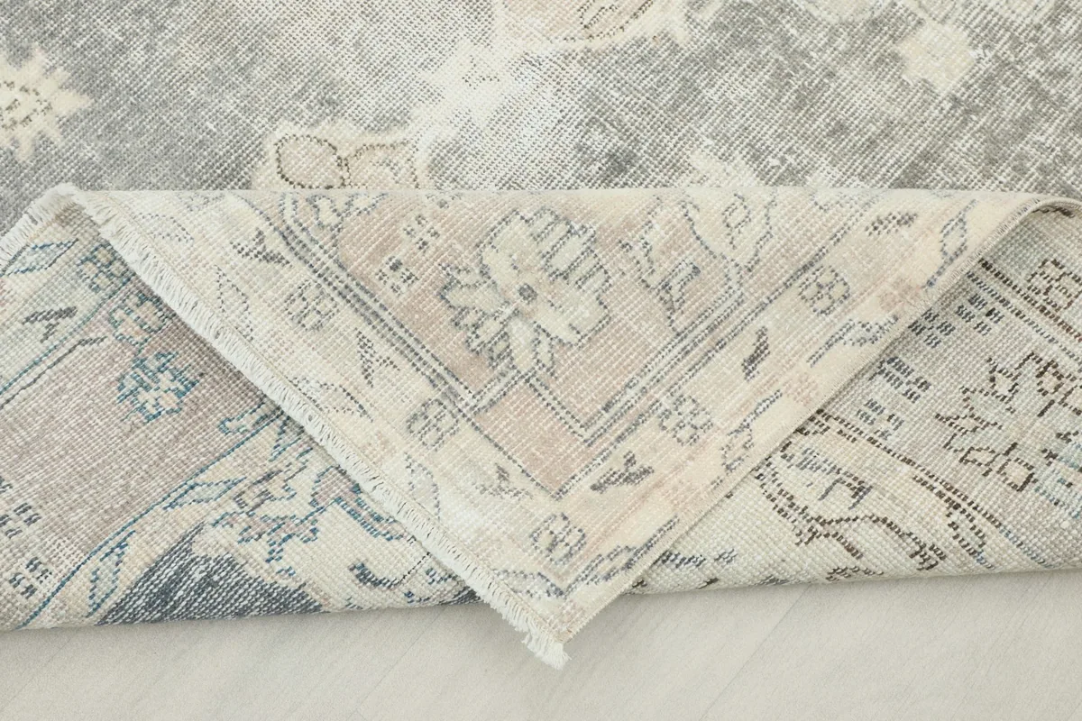 Folded corner of the rug revealing the backside of the hand-knotted cotton foundation