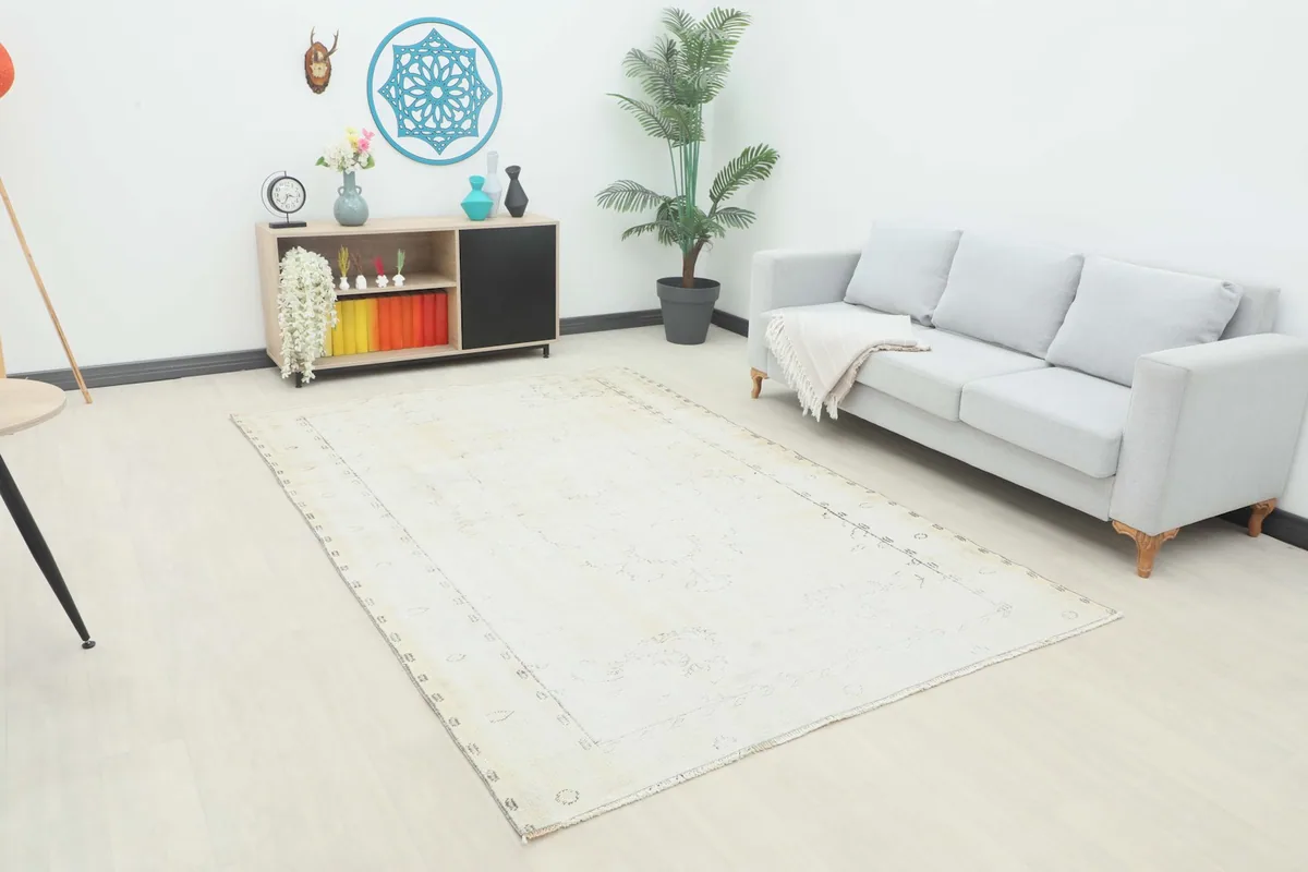 Ivory vintage area rug placed in a bright living room setting with a light gray sofa