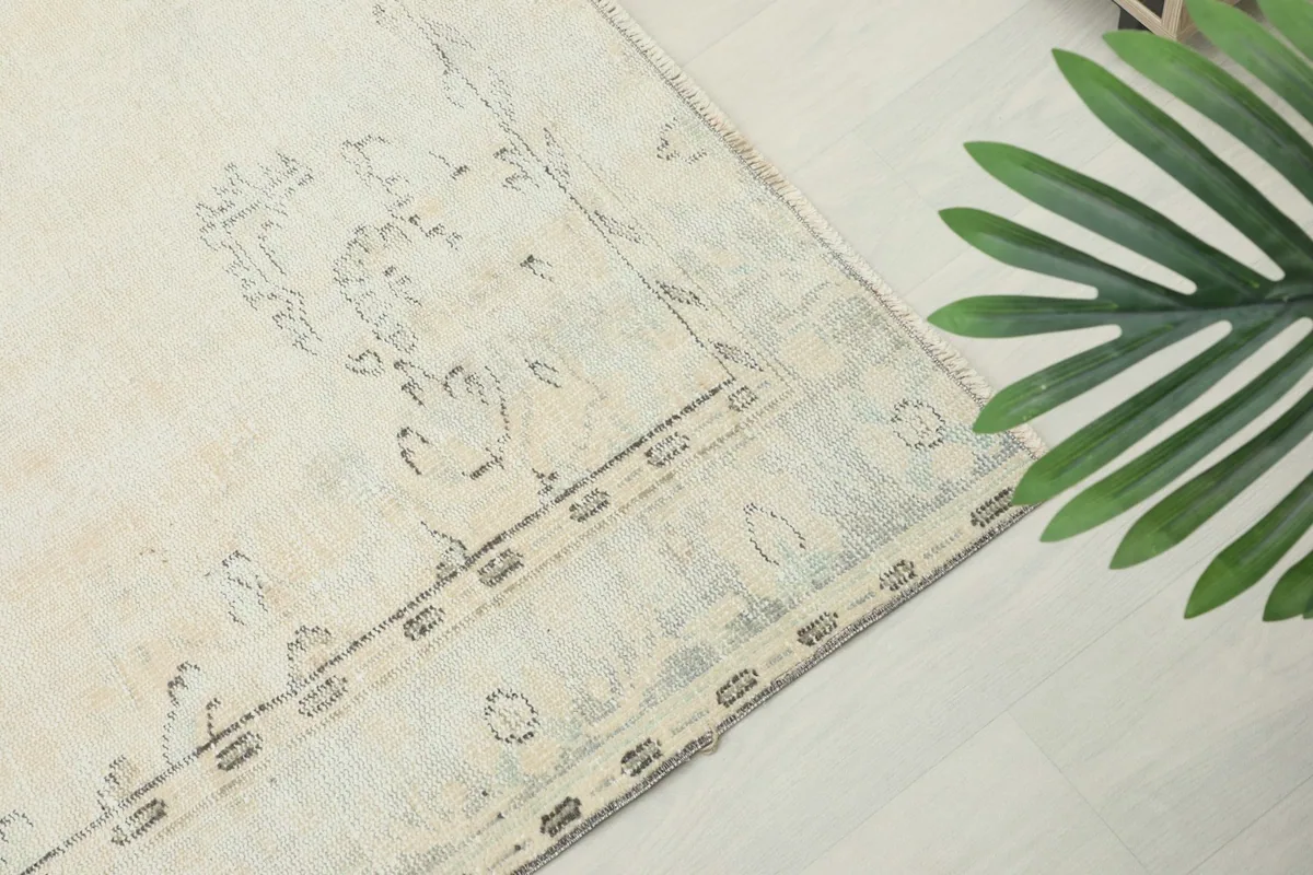 Close-up of the subtle border design and corner details of the vintage ivory Anatolian rug