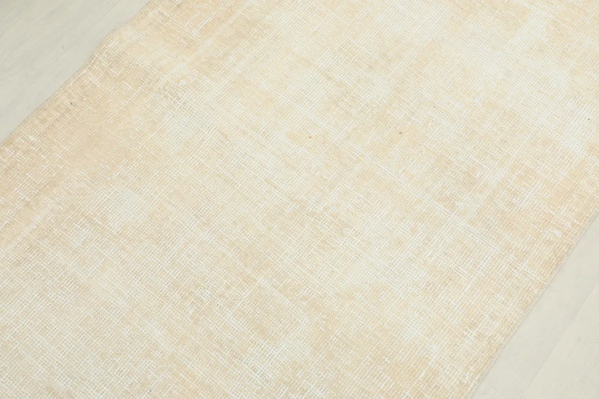 Overhead close-up of the rug's surface, revealing the subtle geometric weave and low pile.
