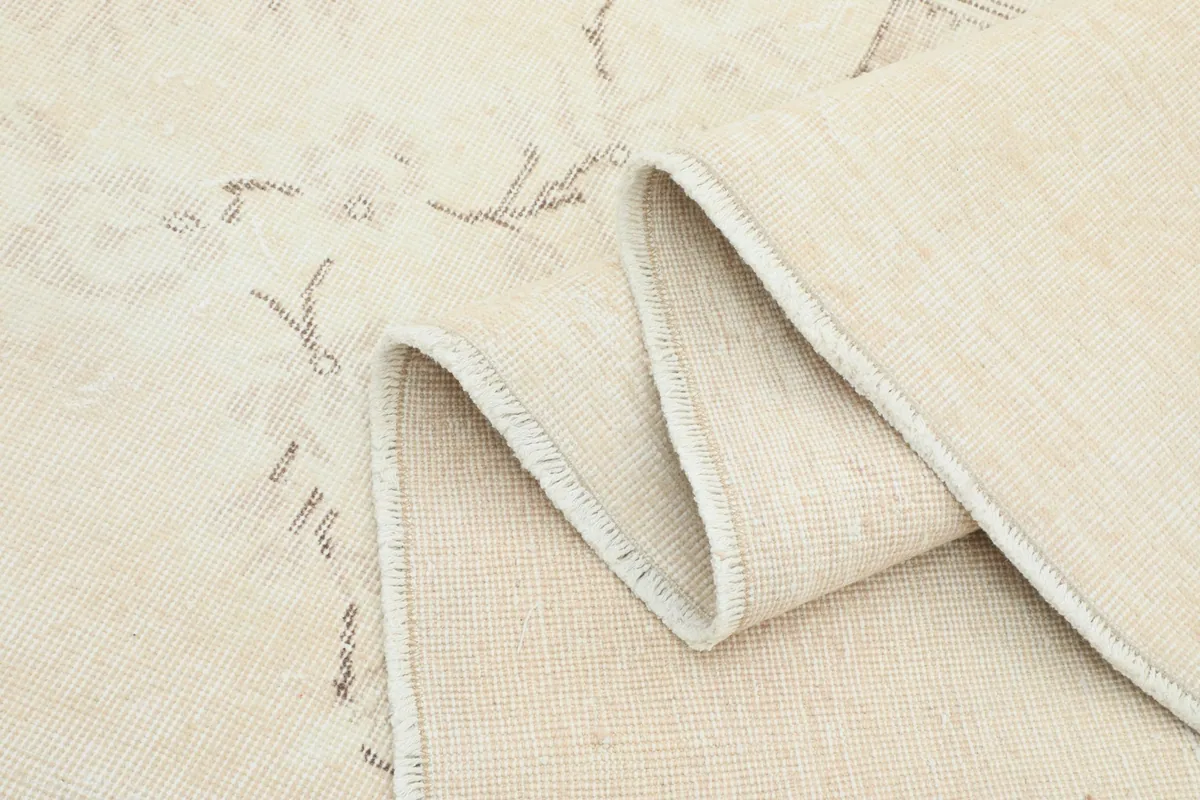 Close-up of the folded edge, showing the texture of the wool pile and the rug's construction.