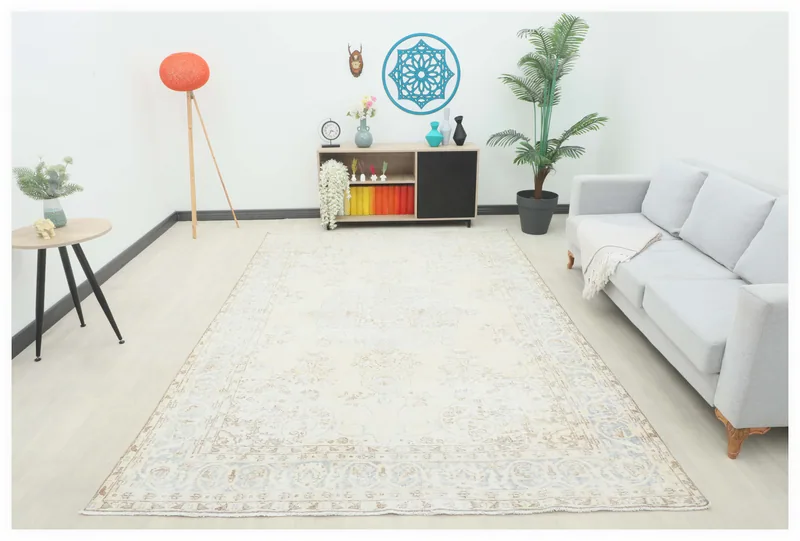 Full top view of a large ivory, blue, and tan vintage Anatolian area rug on a white background.