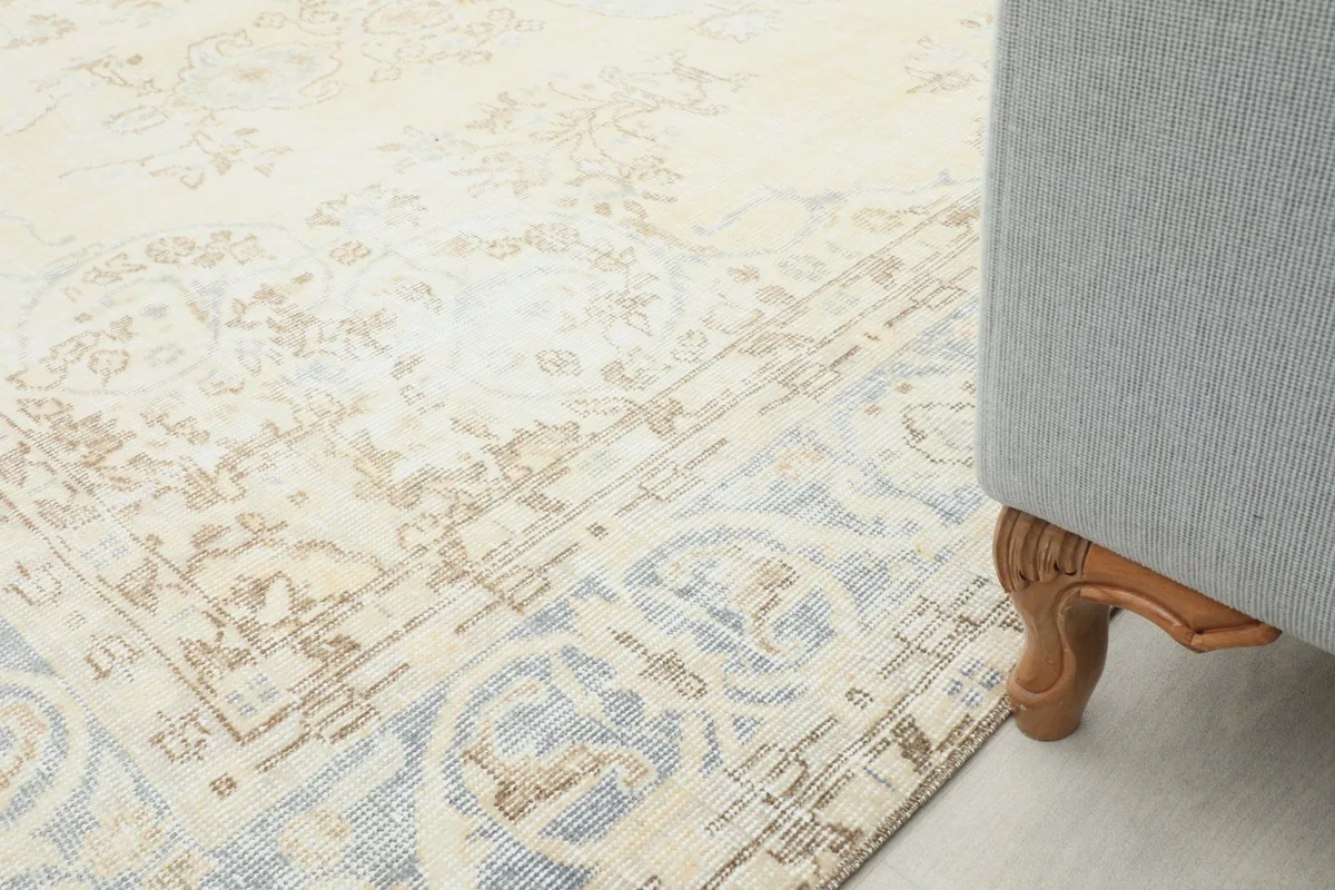 Rug placed next to a sofa leg, illustrating its size and how it fits into a home setting.