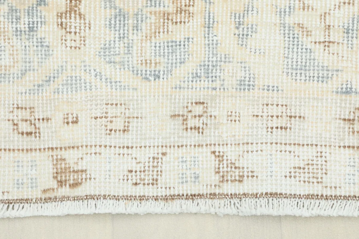 Close-up view of the rug's border showing the short fringe and subtle patterns.