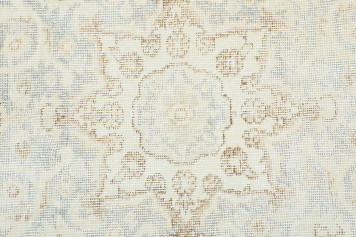 Close-up of the rug's pattern, highlighting the texture and faded colors of the wool pile.