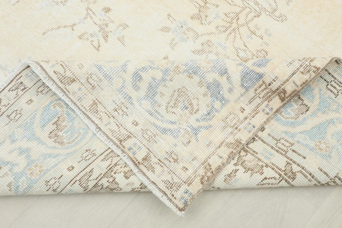 Folded corner of the rug, showing the reverse side and the hand-knotted construction.