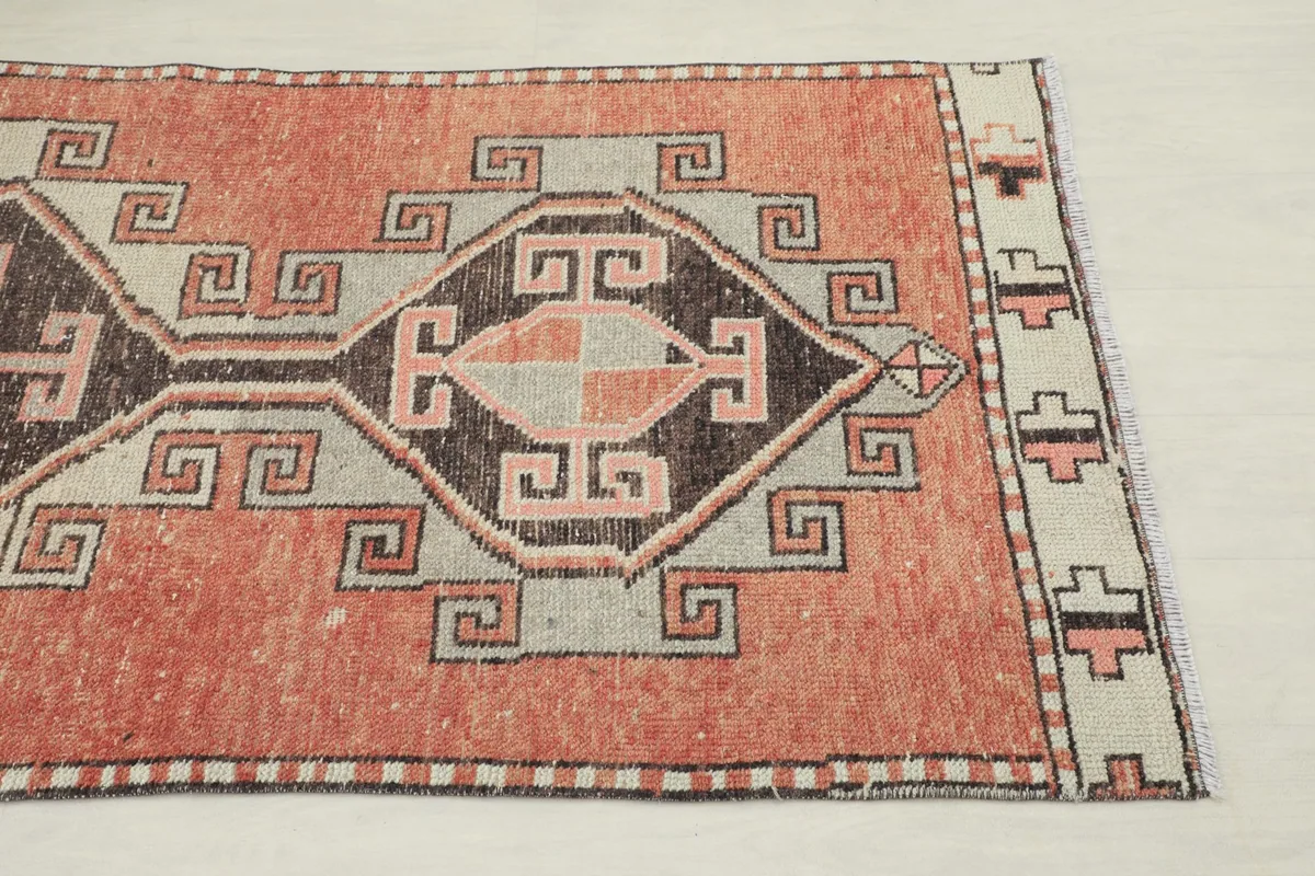 Close-up detail of the geometric pattern and border at one end of the rug