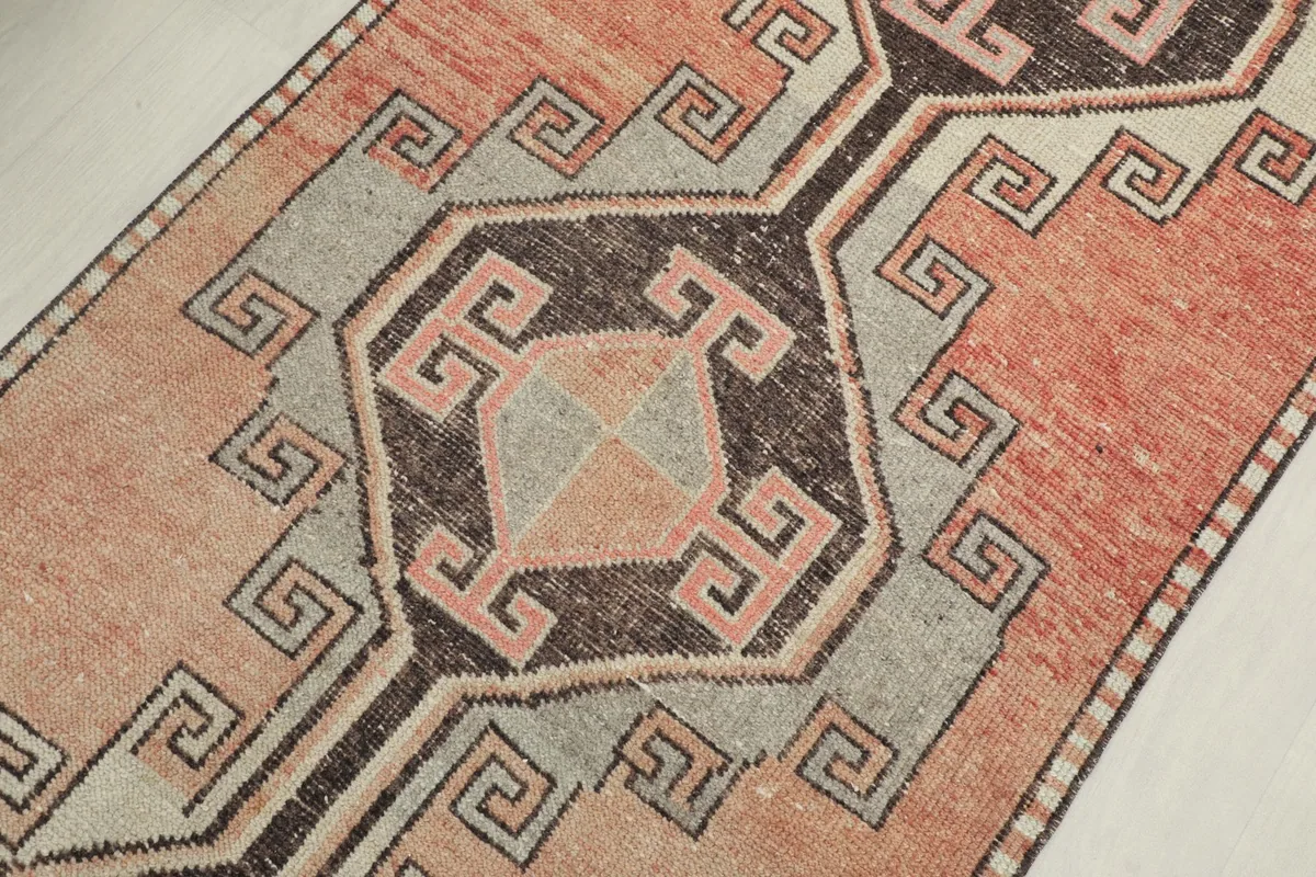Close-up of a central geometric medallion with rust, gray, and beige colors