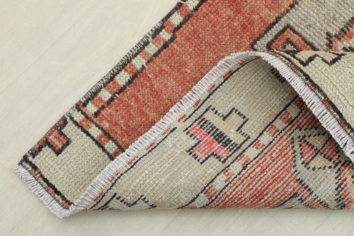 Corner of the rug folded to show the hand-knotted construction and cotton foundation
