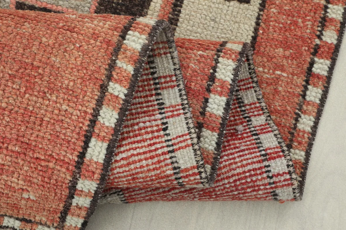 Folded section of the rug showing the reverse side's weave and the pile thickness
