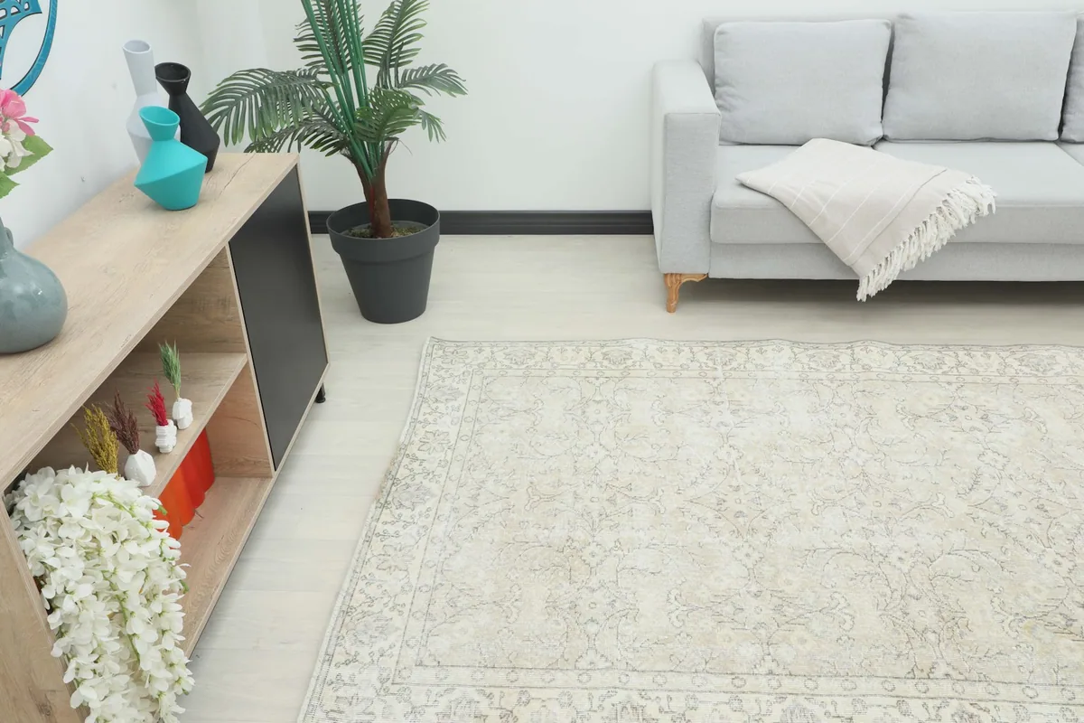 Vintage rug placed in a room, showing its scale next to a sofa and decor