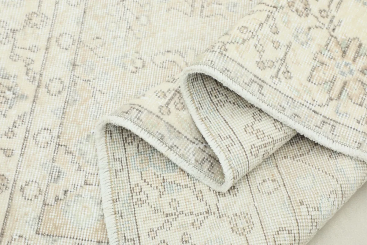 Rug rolled up partially, highlighting the softness of the wool pile and backing