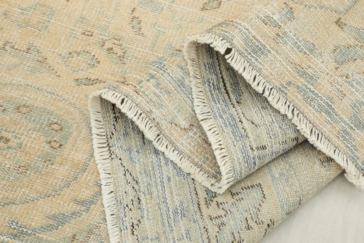 Multiple folds of the rug showcasing the texture of the wool pile and the subtle color variations