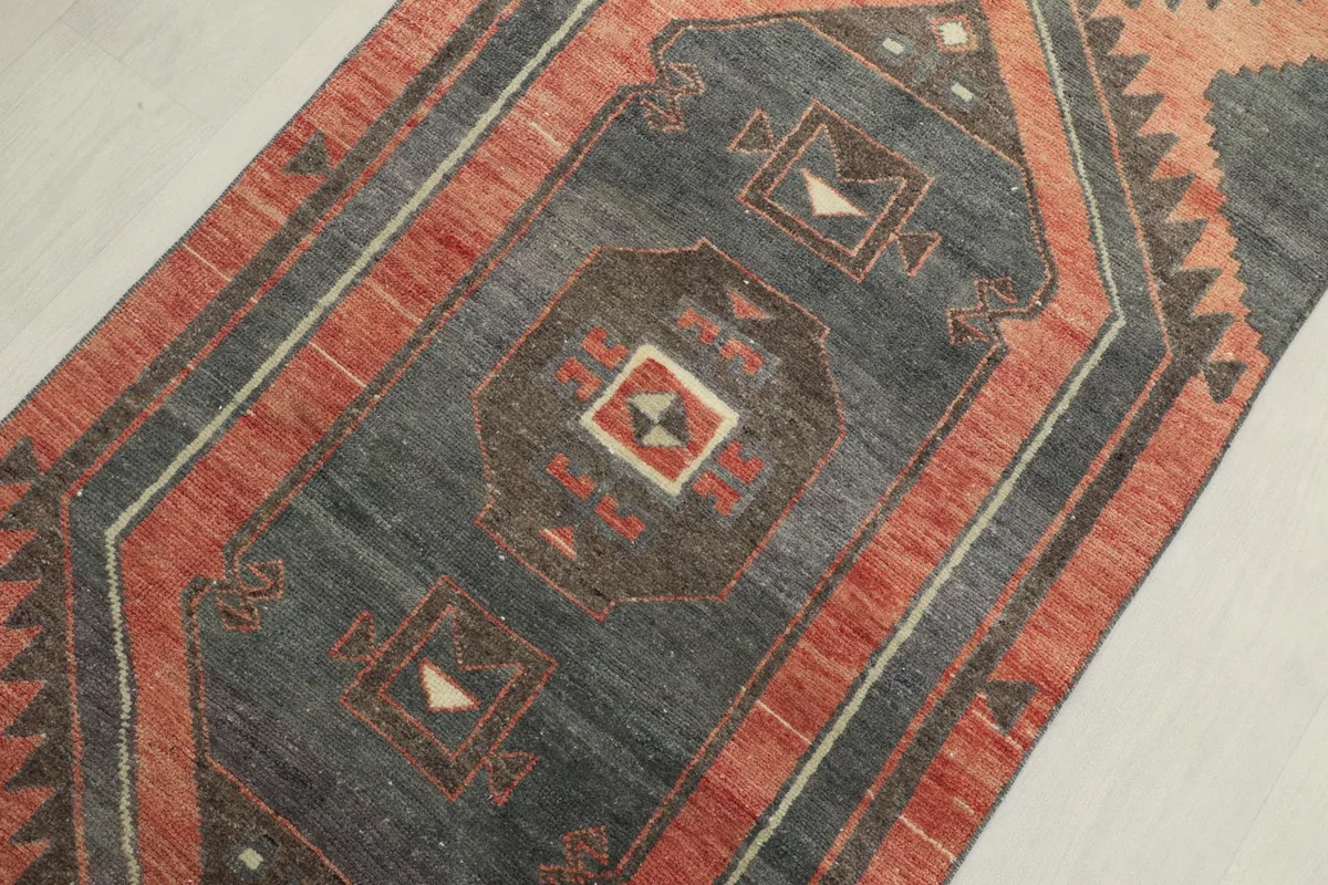 Angled close-up of the central charcoal field with geometric medallions and rust accents