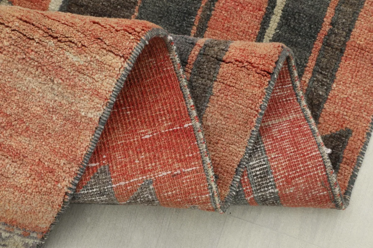 Close-up of the rug folded, showing the thickness of the wool pile and distressed texture
