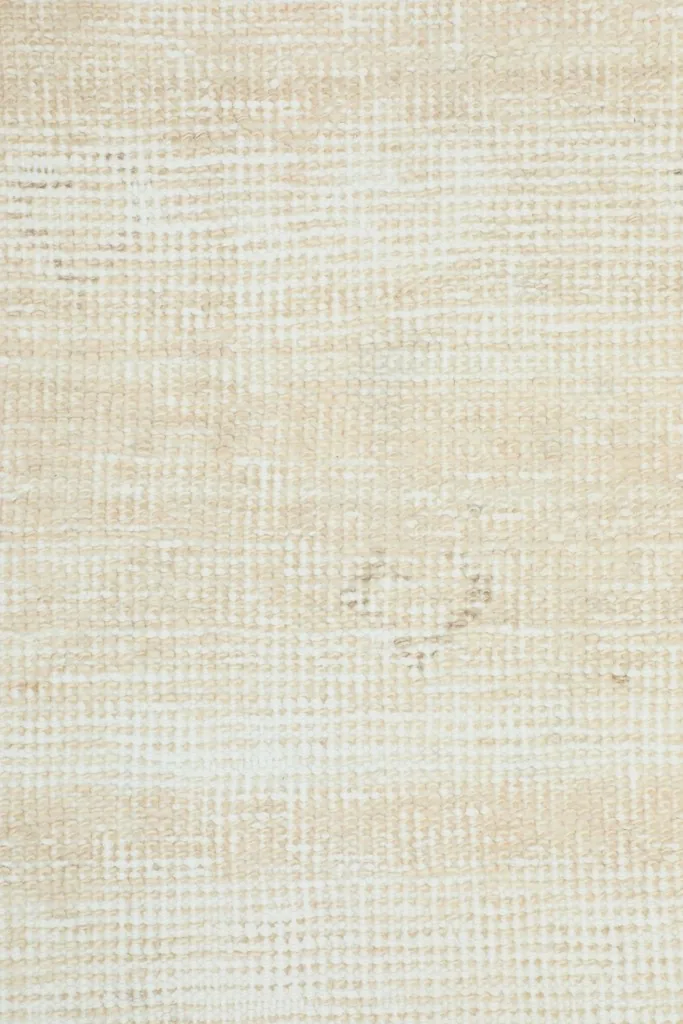 Extreme close-up of the low wool pile, revealing the hand-knotted texture and faded pattern.