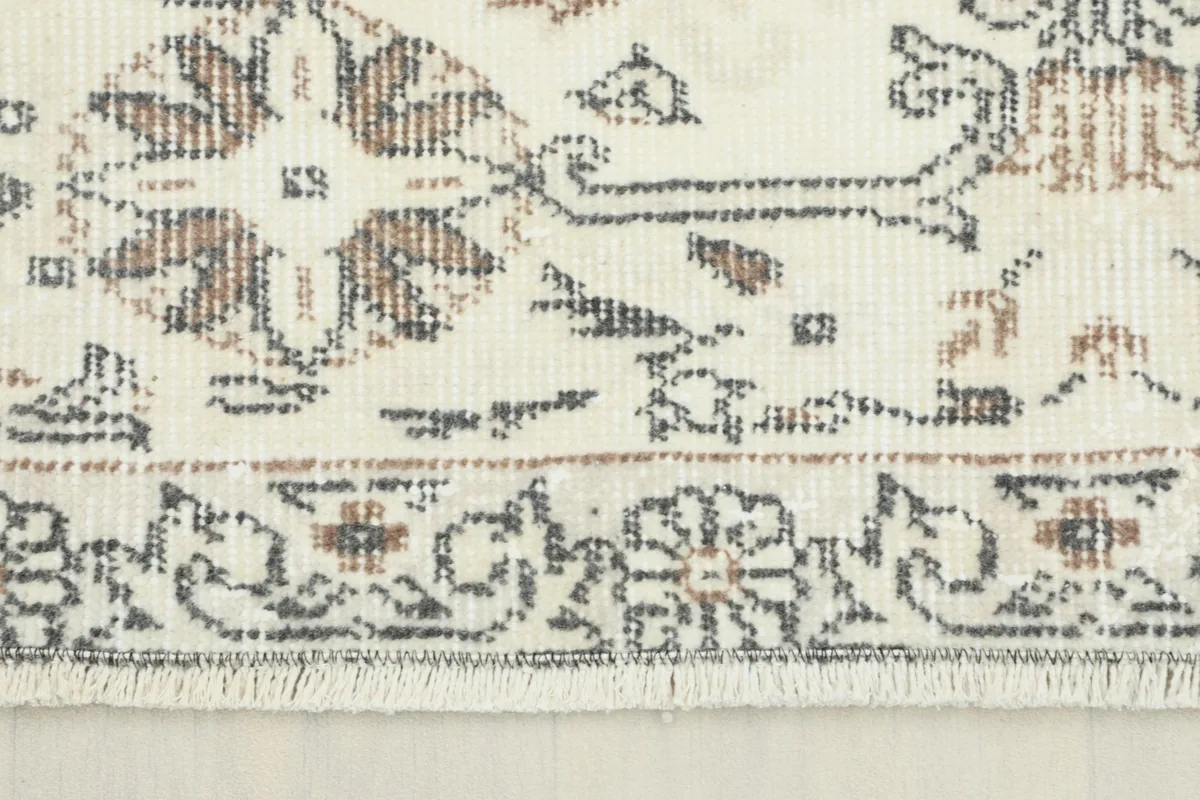 Close-up detail of the rug's border and fringe, showing the hand-knotted wool pile.