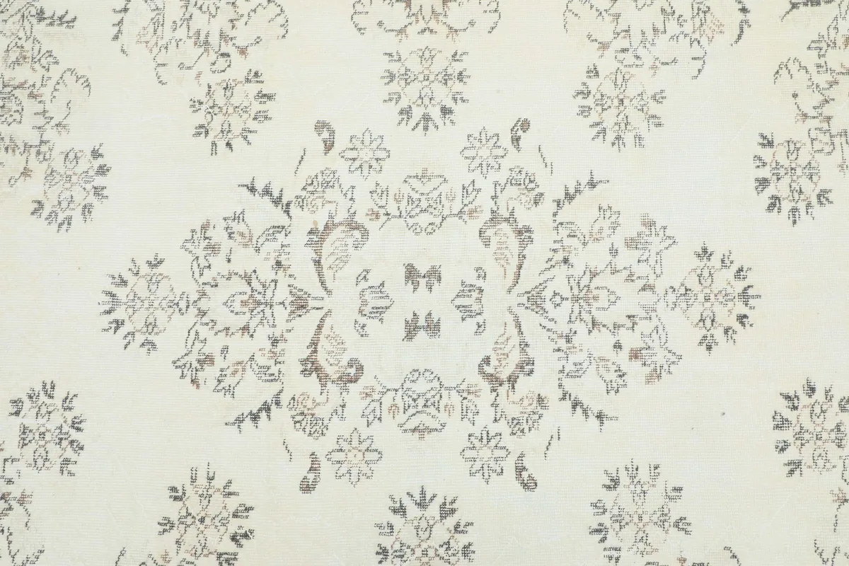 Detailed view of the central medallion and surrounding floral motifs on the ivory field.