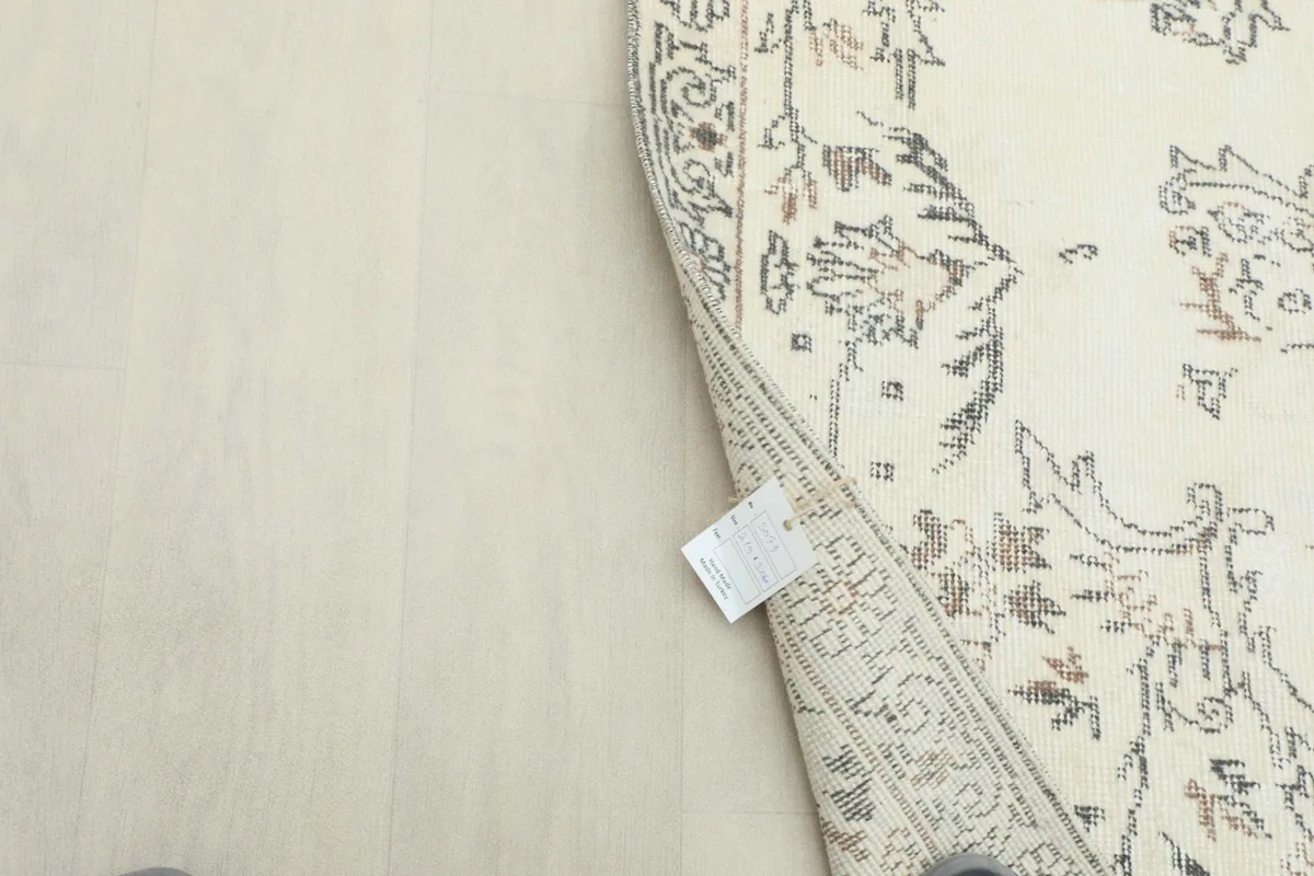 Underside of the rug with a tag, showing the tightly woven cotton foundation.