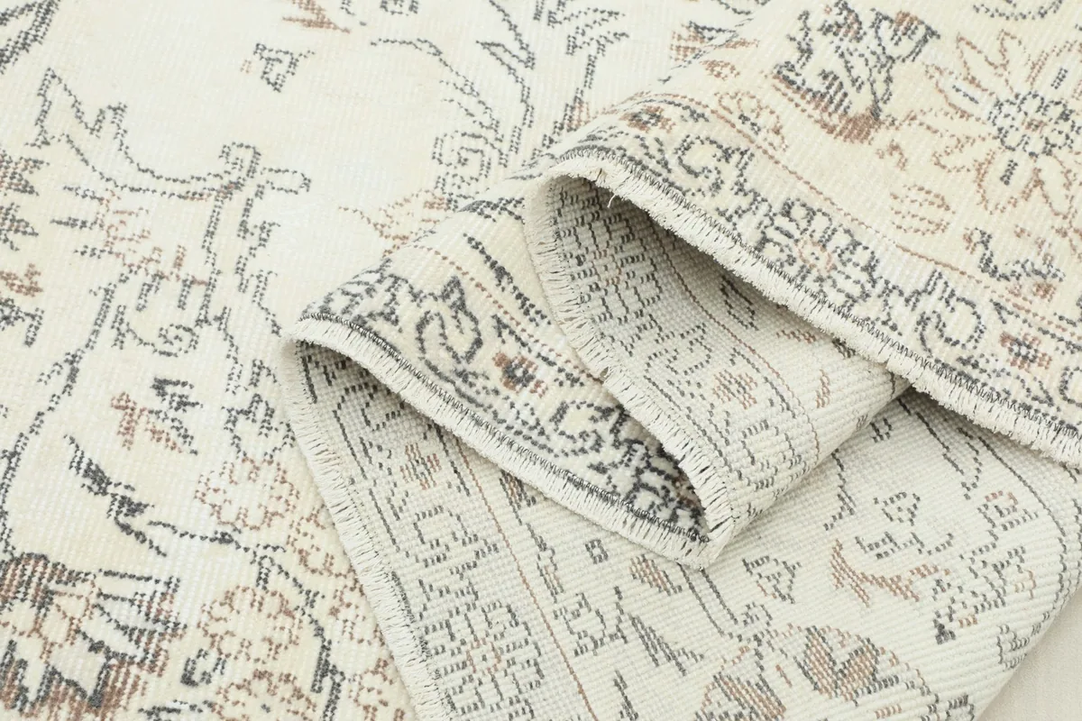Rolled section of the rug, illustrating its flexibility and the density of the wool pile.