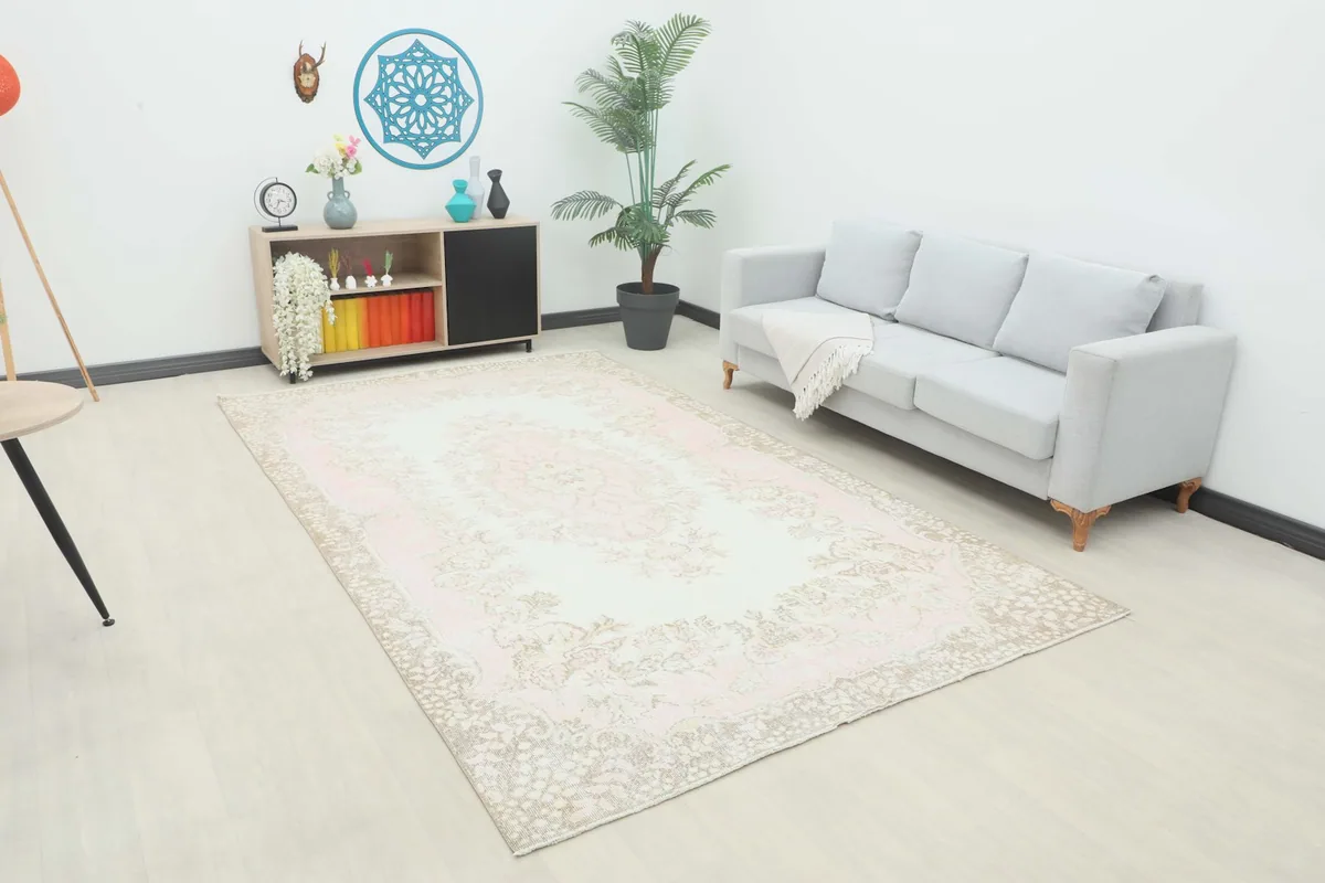 Full view of the large rose and ivory rug placed in a modern living room setting