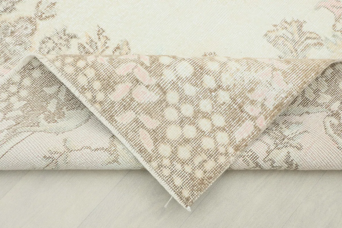 Corner of the rug folded to reveal the hand-knotted wool pile and cotton foundation