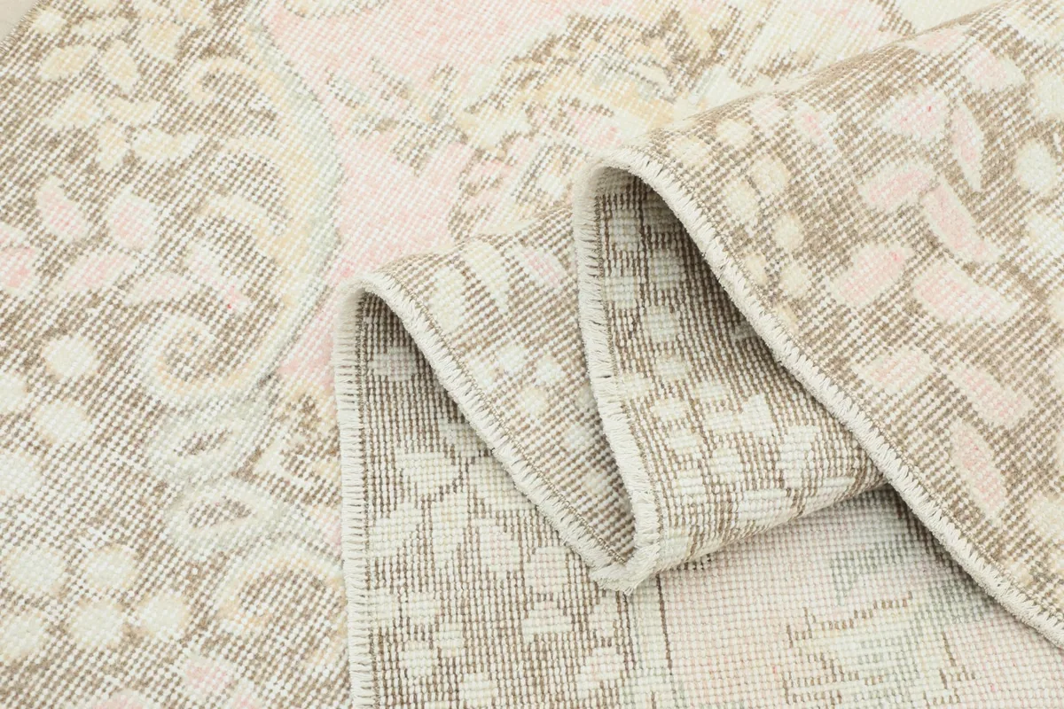 Folded section of the rug showing the texture of the low pile and intricate patterns