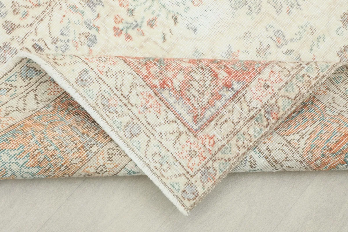 Corner of the rug folded back revealing the cotton foundation and reverse knotting
