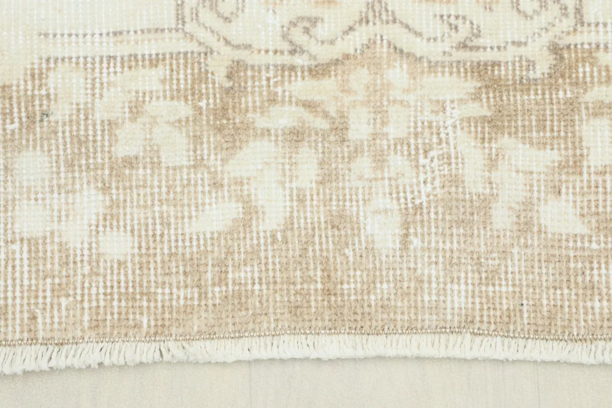Close-up view of the rug's border and fringe, showing the hand-knotted texture.