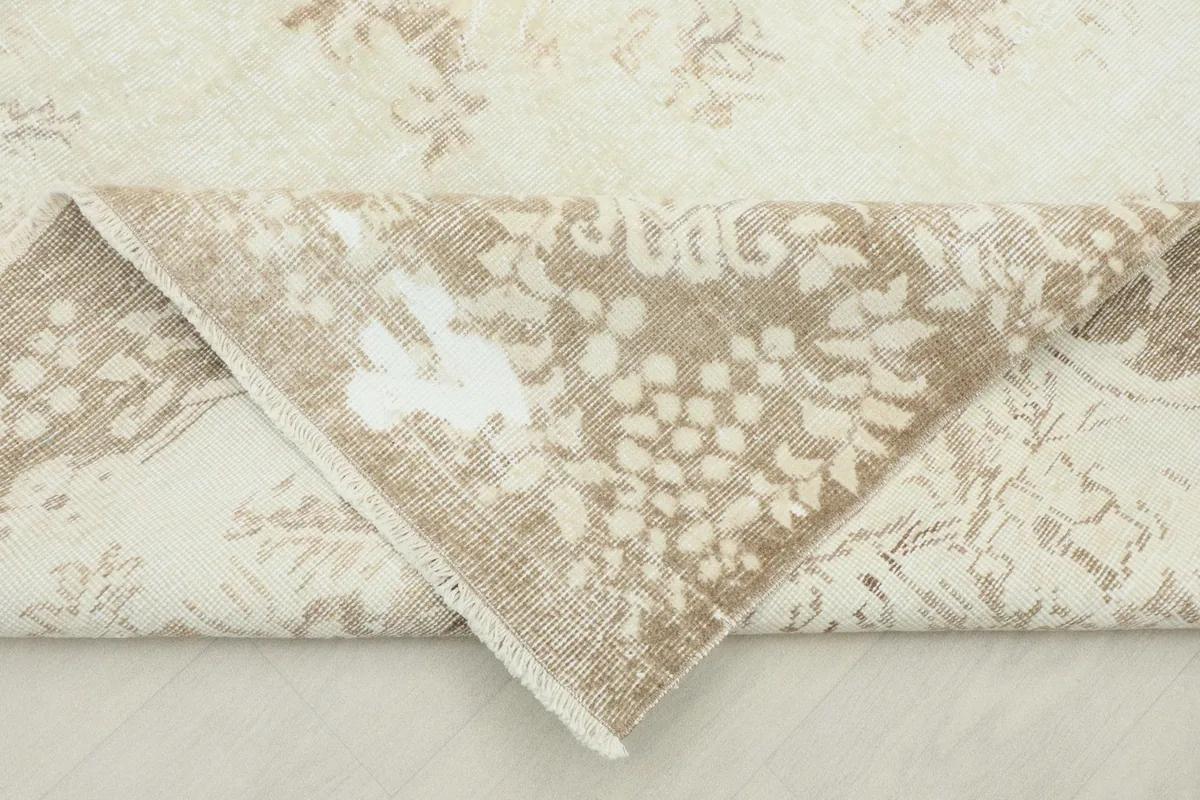 Folded corner of the rug revealing the wool pile and cotton foundation.