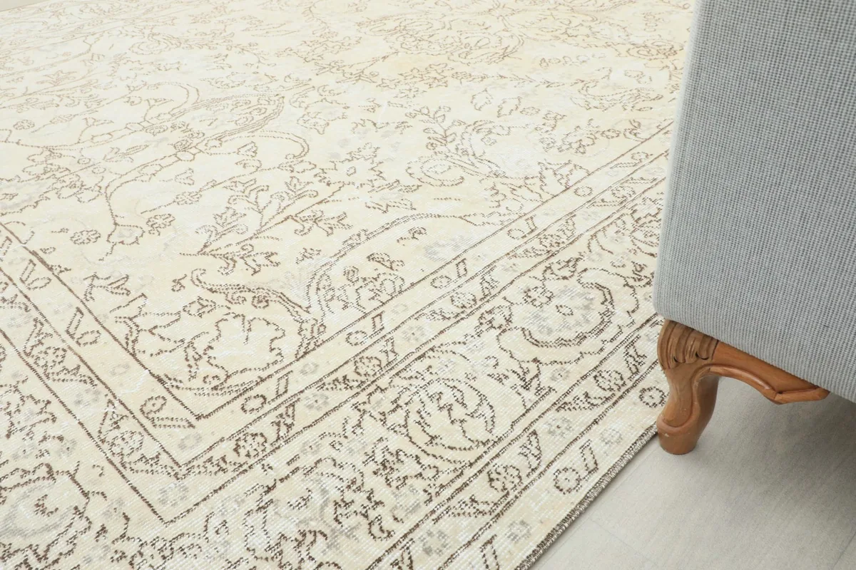 Rug placed next to a light gray sofa, showing the rug's border and overall room integration.