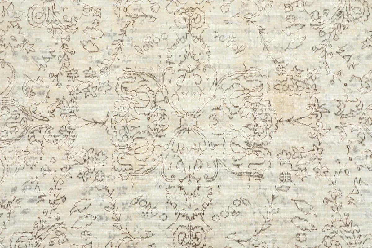 Detailed view of the central medallion design and surrounding floral motifs on the ivory field.