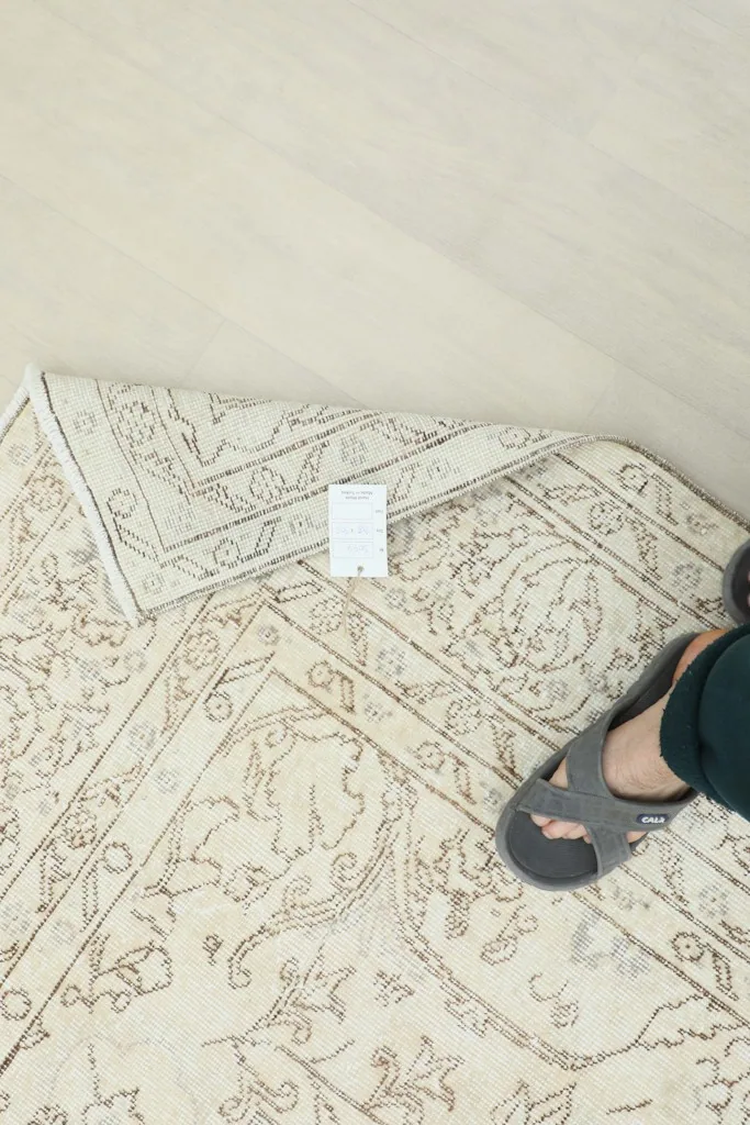 Foot on the rug to illustrate scale and texture, with a size label visible on the rug.