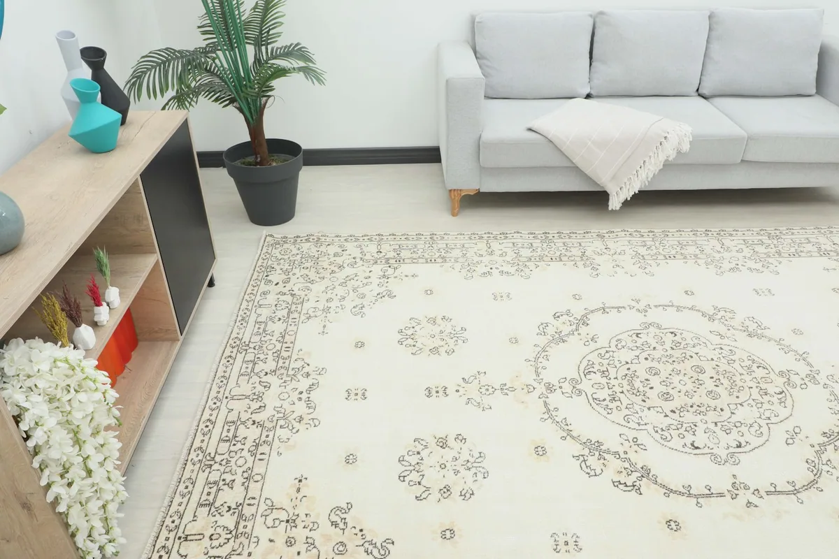 Angled view of the rug in a room, showing its size in relation to a sofa and cabinet