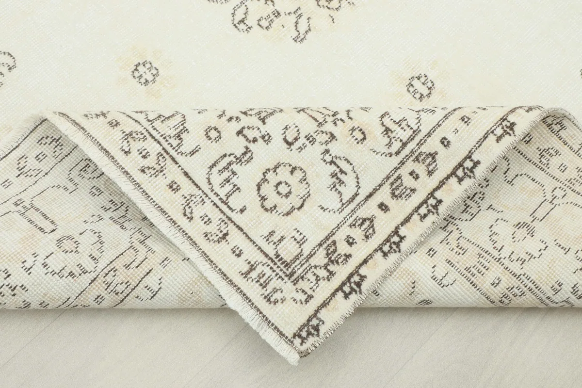 Folded corner of the rug, revealing the back construction and thickness of the hand-knotted wool