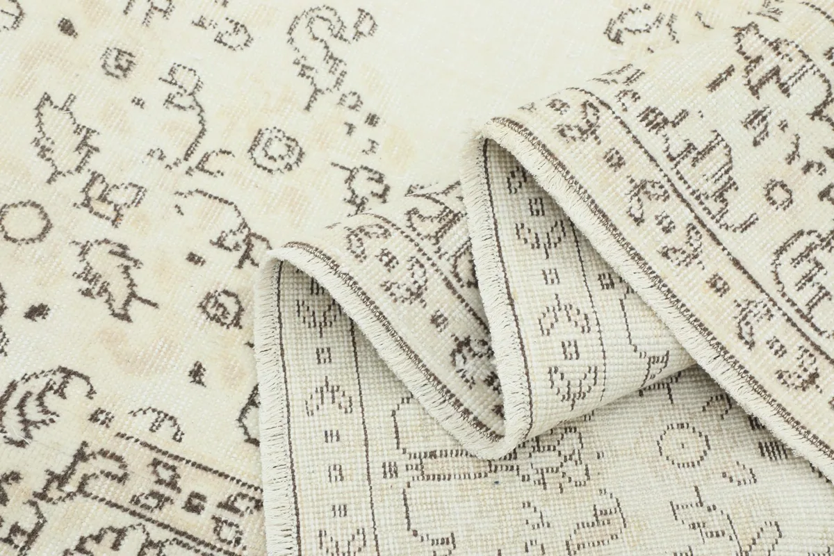 Side view of the rug folded, showing the intricate patterns and wool pile texture