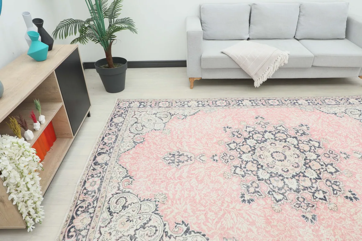 Angle view of the rose and navy vintage rug in a living space, showing its scale
