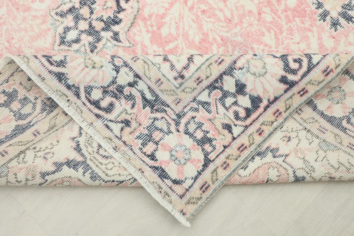 Folded corner of the rug revealing the hand-knotted cotton foundation and wool pile