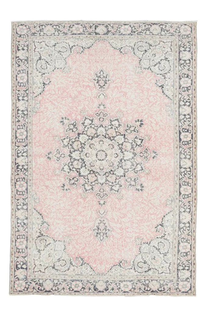 Full overhead view of the rose and navy vintage Anatolian rug on a white background